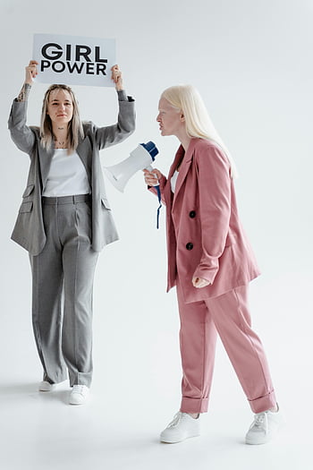 igualdad de género, poder femenino, mujeres protestando, blazer rosa, chaqueta gris, megáfono, cartel, protesta en interiores, trajes, activismo, empoderamiento