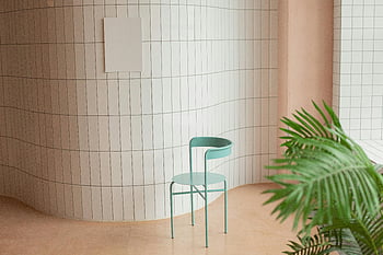 zöld szék, fehér csempézett fal, cserepes növény, modern dekoráció, beltéri környezet, nyugodt környezet, tábla, ívelt fal, minimalista design, beltéri növények, kortárs bútorok