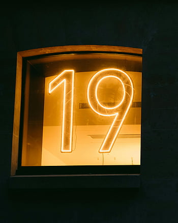 neon number 19, close-up, window display, warm glow, neon sign, number nineteen, illuminated display, glowing number, neon lighting, architectural detail, night scene