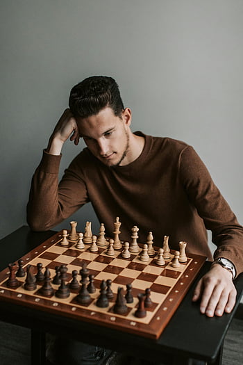Muž v hnědém svetru, Hrát šachy, šachová hra, cílená strategie, šachovnice, šachové figurky, Vnitřní nastavení, koncentrace, ležérní oblečení, Hra v šachy, Strategické myšlení