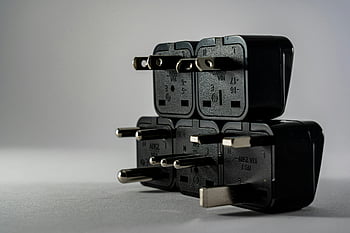 black plugs, electrical adapters, stacked adapters, gray background, close-up photo, black electrical, adapter stack, plug stack, electrical plug, adapter close-up, gray surface