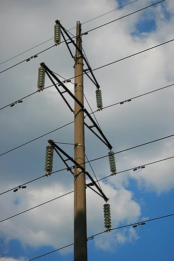 electric poles, power lines, cloudy sky, high-angle view, utility poles, overhead wires, electrical infrastructure, outdoor scene, blue sky, power distribution, transmission lines