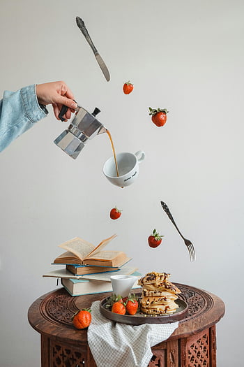 coffee pouring, Moka pot, floating strawberries, pancakes, culinary art, cutlery, creative composition, breakfast scene, strawberries, coffee cup, floating objects