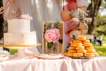 dessert table, baby shower, outdoor dessert table, cake, donuts, beautifully decorated, pink flowers, outdoor event, baby shower decorations, pink balloons, pastel colors