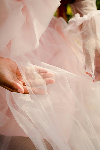female hands, pink tulle, dress fabric, close-up, delicate details, soft texture, woman's hand, gentle hold, tulle dress, fabric texture, pink dress