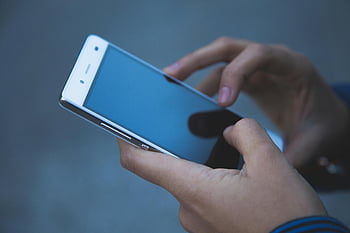 persona che tiene smartphone, smartphone bianco, Tecnologia di comunicazione moderna, impostazione casuale, Mani Che Tengono Telefono, ambientazione esterna, tecnologia per smartphone, dispositivo di comunicazione, tecnologia mobile, Uso casuale, smartphone in mano