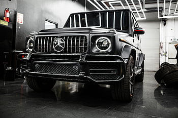 Black Mercedes-Benz G-Class, luxury SUV, modern garage, striking design, Mercedes-Benz, G-Class SUV, black car, high-end vehicle, garage setting, automotive photography, luxury vehicle