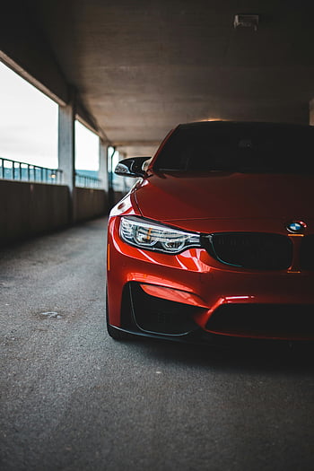 red sports car, urban parking garage, modern design, luxury vehicle, dynamic shot, red car, parking lot, sports car, urban setting, modern luxury, car photography