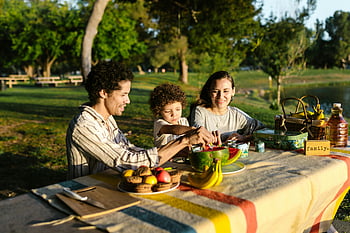 családi piknik, friss gyümölcsök, park, napfény, vidám család, szabadtéri étkezés, piknik asztal, természet, nyári, összetartozás, pihenés