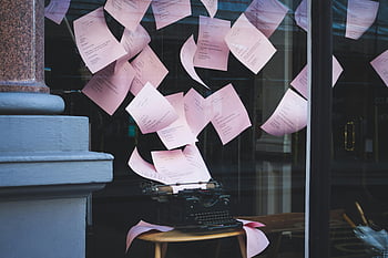 typewriter, table, vintage typewriter, pink papers, floating papers, window display, artistic display, indoor setting, window setting, vintage, papers