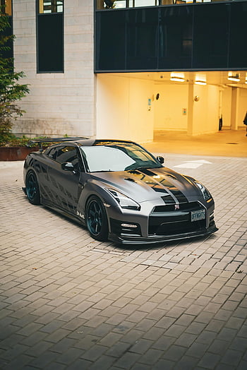 Nissan GT-R, black Nissan GT-R, urban area, sleek design, modern car, parked car, building front, city street, sports car, urban parking, stylish vehicle