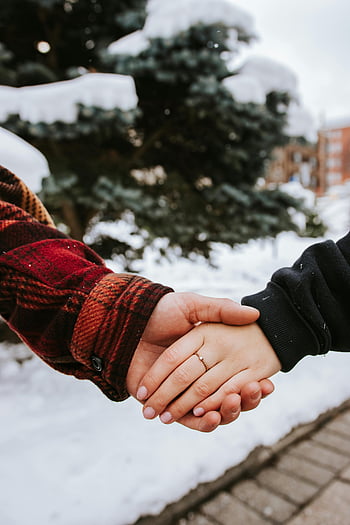 couple holding hands, winter romance, outdoor love, snowy background, closeup hands, romantic couple, winter couple, love in winter, romantic scene, winter love, snow-covered trees