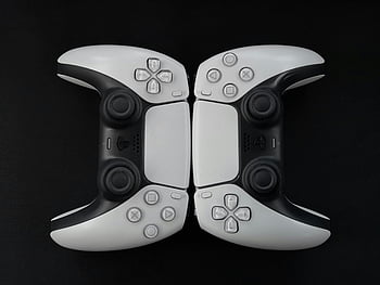PlayStation controllers, close-up, modern gaming controllers, white controllers, black surface, top-down view, gaming accessories, video game controllers, dual controllers, gaming equipment, PlayStation hardware