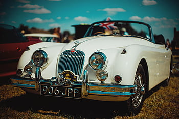 teures Retro-Auto, Vintage weißes Cabrio, auf Gras geparkt, Outdoor -Ausstellung, sonniger Tag, britische Flagge, klassisches Auto, Veranstaltung im Freien, Autoshow, Retro -Fahrzeug, Oldtimer