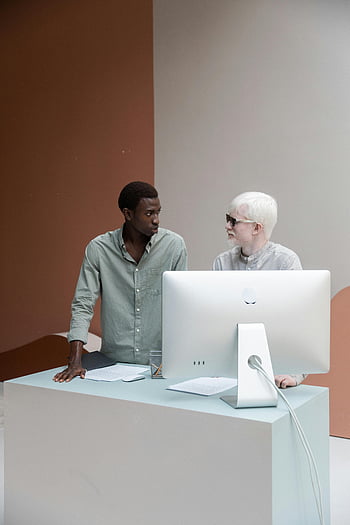 Разнообразни колеги, обсъждане на работата, компютър, Модерно работно място, мулти-етнически, двама колеги, професионална обстановка, офис среда, съвместна дейност, сътрудничество, технология