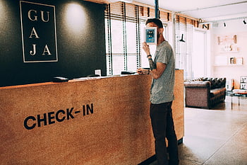 uomo, volto coprente, telaio, banco accettazione, tenendo un libro, Hall dell'hotel moderna, registrare, scrivania di legno, impostazione interna, abbigliamento casual, braccio tatuato