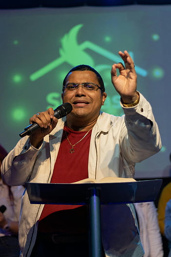man giving speech, passionate speech, indoor event, microphone, public speaking, speaker, audience, podium, event speaker, presentation, conference