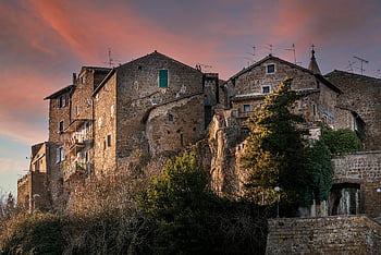 Calcata, Italy, medieval architecture, aged stone houses, hillside village, sunset sky, charming town, European village, historic buildings, rustic charm, sunset photography