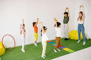 children stretching, teachers stretching, indoor classroom, vibrant classroom, kids exercise, stretching exercises, classroom activity, group exercise, educational setting, healthy lifestyle, teacher and students