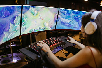 League of Legends, young woman, gaming, multi-screen setup, vibrant visuals, headphones, keyboard, mouse, esports, computer setup, intense gameplay