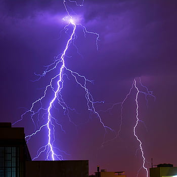 thunder striking, lightning bolt, city skyline, night photography, powerful lightning, urban landscape, electrical storm, night sky, building silhouette, natural phenomenon, thunderstorm scene