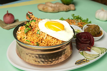 fried rice, sunny side egg, vegetables, traditional plate, delicious meal, garnished dish, rice dish, egg topping, vegetable garnish, traditional serving, plated dish