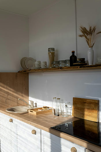 Design de cuisine moderne, Cuisine minimaliste, accents en bois, cuisine ensoleillée, décor moderne, intérieur de cuisine, comptoir en bois, étagères ouvertes, armoires blanches, bocaux en verre, planche à découper