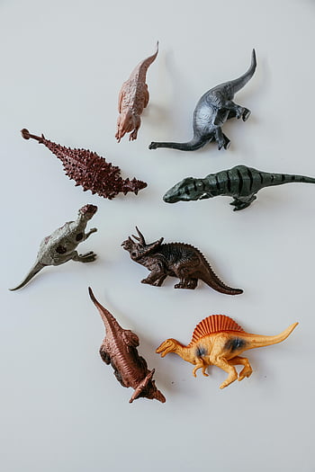 plastic dinosaur toys, top view, miniature toys, white background, various dinosaurs, toy collection, dinosaur figures, plastic figures, toy dinosaurs, dinosaur models, toy display