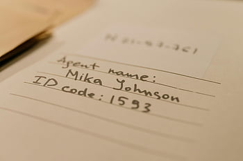 carnet, document manuscrit, nom de l'agent, code d'identification, texte personnel, photo en gros plan, texte manuscrit, document, page de cahier, détails de l'agent, numéro d'identification