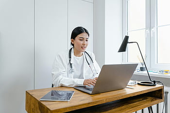 female doctor, white coat, laptop, online consultation, office, desk, stethoscope, medical professional, healthcare worker, telemedicine, computer
