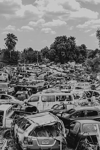 grayscale photo, broken vehicles, monochrome image, crowded junkyard, abandoned cars, cloudy sky, vehicle scrapyard, car wreckage, auto salvage, junkyard scene, monochrome photography