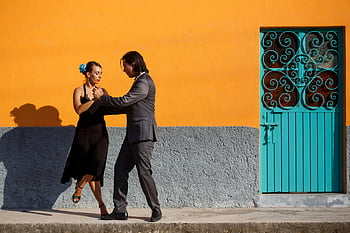 Tango Dance, pár tanec, Jízdní tanec, oranžové zdi, tyrkysové dveře, pouliční představení, venkovní tanec, Muž a žena tančí, dekorativní dveře, Urban Dance Scéna, zářivé barvy
