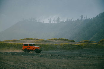 Orange Geländewagen, Schotterstraße, Ost-Java, Indonesien, Scenic Mountains, Geländewagen, Outdoor-Abenteuer, natürliche Landschaft, Reisefotografie, Abenteuerreisen, Bergstraße