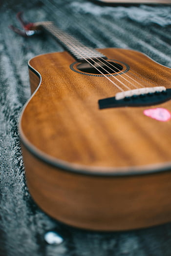 acoustic guitar, wooden guitar, guitar strings, guitar pick, close-up guitar, selective focus, detailed guitar, musical instrument, guitar body, guitar sound hole, guitar frets