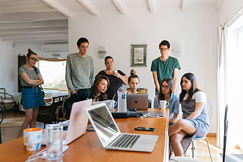 group of people, watching on laptop, young professionals, collaborative meeting, modern office setting, team meeting, office environment, group discussion, professional collaboration, office workspace, modern workspace