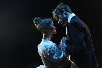 Uomo e donna romantici, costumi d'epoca, performance sul palco, scena romantica, attori, luci di scena, momento intimo, spettacolo teatrale, Abbigliamento vintage, illuminazione drammatica, coppia romantica