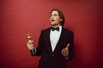 hrdý muž, držení ocenění, zkušený muž, smoking, trofej, triumf, uznání, Červené pozadí, socha oscara, úspěch, oslava