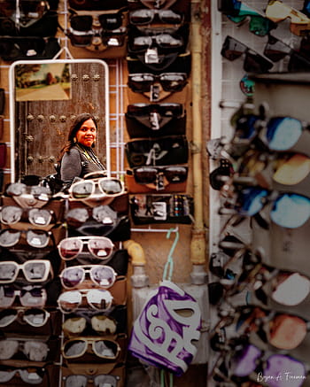 sunglasses, mirror, candid moments, street photography, reflections, urban life, street markets, visual storytelling, unexpected frames, depth in frame, moody tones