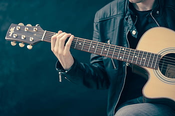 akustische Gitarre, braune und schwarze Gitarre, Musiker spielt, Lederjacke, Nahansicht, Gitarrenspieler, akustische Musik, Musikinstrument, Gitarrensaiten, Gitarrenhals, dunkler Hintergrund