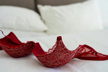 Červená krajka podprsenka, bílá postel, Stylová ložnice, červené spodní prádlo, krajková podprsenka, elegantní nastavení, ložnice dekor, červená krajka, bílé ložní prádlo, scéna ložnice, červená podprsenka