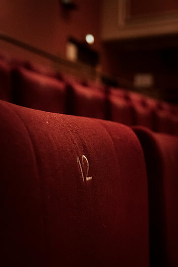 Czerwone aksamitne siedzenia, fotele kinowe, Numer dwanaście, haftowany numer, Atmosfera retro, zdjęcie zbliżenie, czerwone siedzenia, Atmosfera kinowa, fotele teatralne, kino vintage, Czerwone siedzenia kinowe