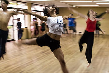 group dance class, dynamic dance, diverse techniques, spirited expressions, indoor dance, dance studio, people dancing, active movement, dance expressions, group activity, dance techniques