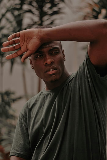 man, crew-neck t-shirt, green t-shirt, hand raised, portrait, looking away, thoughtfully, outdoor, casual, fashion, lifestyle