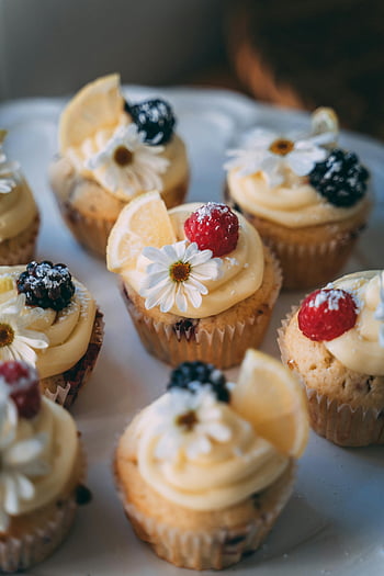 Zitronencupcakes, creme zuckerguss, verschiedene Muffins, Zitronenscheiben, Beeren, Blumendekorationen, flacher Fokus, Dessert, Backwaren, süße Leckereien, Cupcake -Platte
