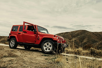 SUV rosso, strada sterrata, paesaggio di montagna, cielo nuvoloso, rosso vivace, parcheggiato suv, fuoristrada, scena all'aperto, sfondo naturale, veicolo avventura, terreno accidentato