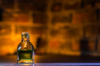potion bottle, close-up shot, mystical potion, warm glow, brick background, green liquid, glass bottle, cork stopper, magical potion, fantasy potion, potion container