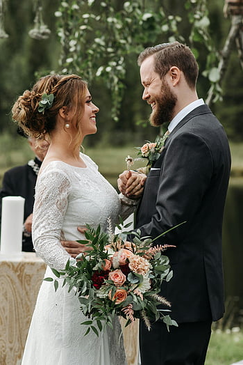 gelukkige bruid, bruidegom, buiten bruiloft, ceremonie, glimlachen, handen vasthouden, vrolijk paar, Bruidsboeket, natuurlijke omgeving, romantisch moment, huwelijkskledij