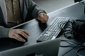 人タイピング、 灰色のジャケット、 キーボード、 モダンワークスペース、 洗練されたキーボード、 閉じる、 キーボード上の手、 机のセットアップ、 オフィス環境、 ヘッドホン、 ノートパソコン