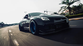 黒のスポーツカー、 日産gt-r、 都市通り、 動いている、 洗練されたデザイン、 ブルーホイール、 アーバンドライビング、 高性能車両、 道路の動き、 車の写真、 自動車写真