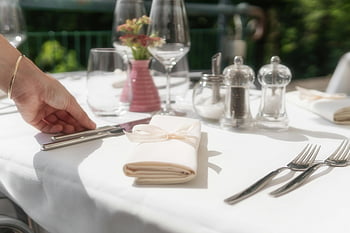dining table setup, luxurious table setting, white napkin, ribbon, fine glassware, silverware, tableware, elegant dining, table arrangement, outdoor dining, table decor